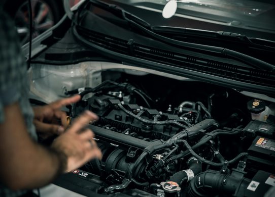 Profesionalus mechanikas atlieka automobilio patikrą prieš kelionę moderniame servise.