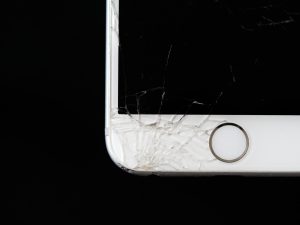 Meistras taiso sudužusį telefono ekraną po stipraus stiklo pažeidimo