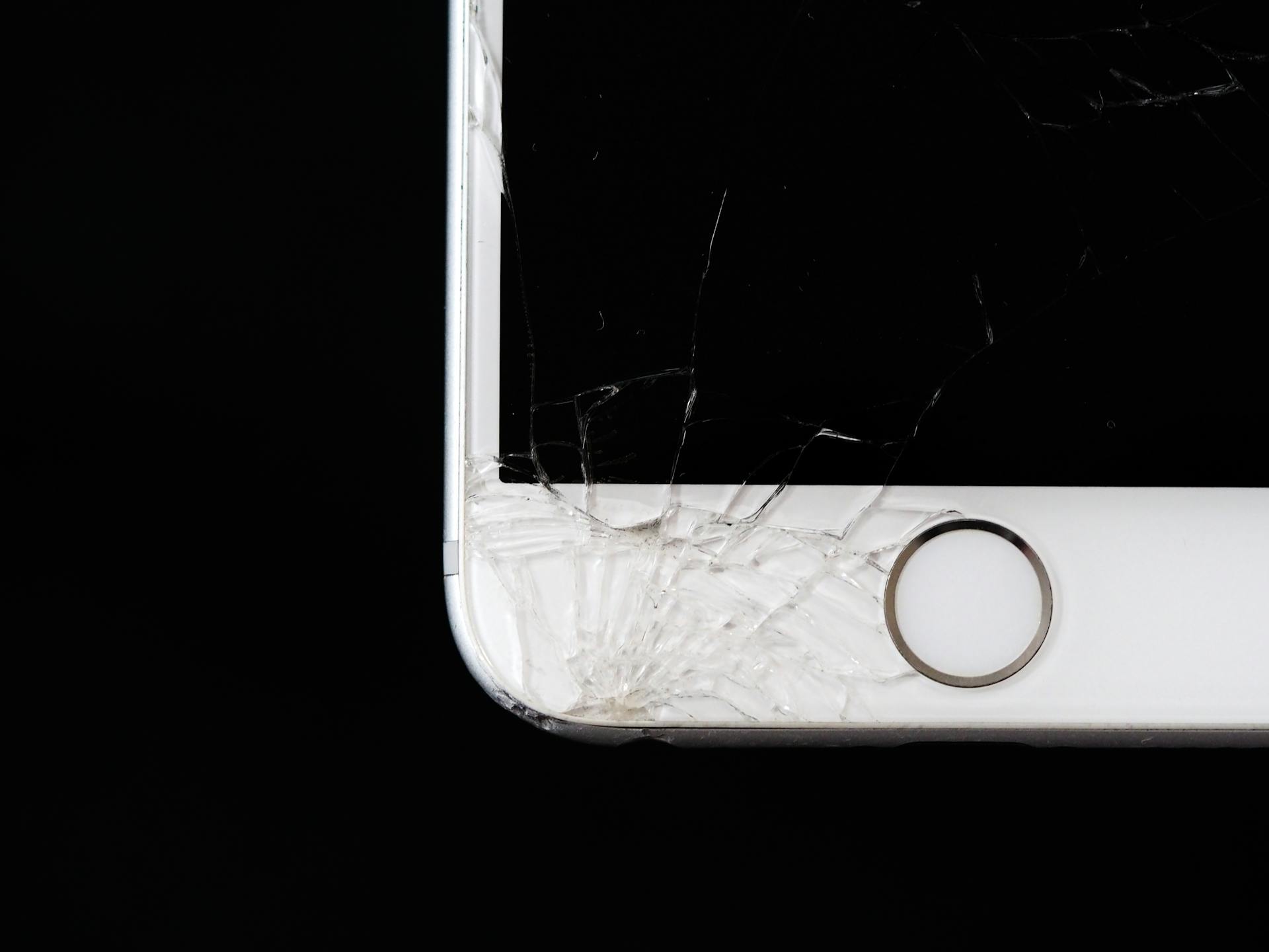 Meistras taiso sudužusį telefono ekraną po stipraus stiklo pažeidimo