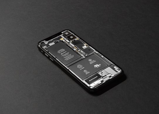Išmanusis telefonas su senkančios baterijos indikatoriumi naudojamas žiemos sąlygomis.